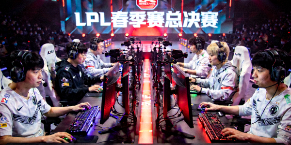 LPL春季赛总决赛精彩瞬间，两支队伍在舞台上激烈交锋，灯光聚焦于选手席